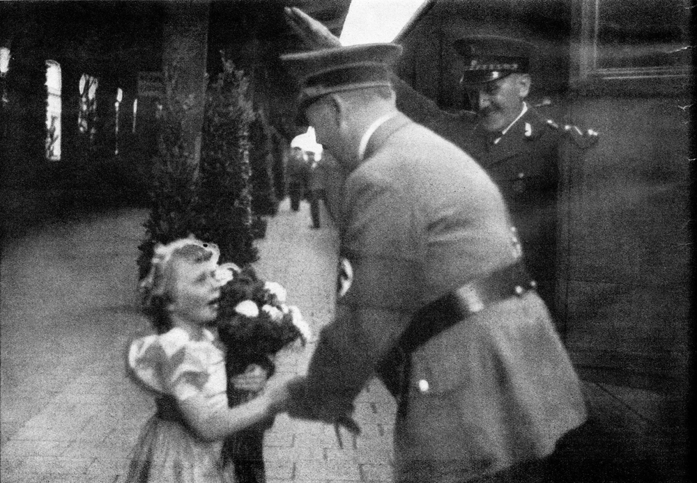 A little girl welcomes Adolf Hitler in Nuremberg's train station, as he arrives for the 1936 Reichsparteitag